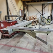 Scie à format manuelle utilisée pour tronçonnage et délignage de panneaux bois.